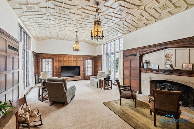 living area with a notable chandelier, a premium fireplace, light carpet, high vaulted ceiling, and brick ceiling