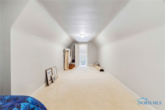 additional living space with vaulted ceiling, light carpet, and baseboards