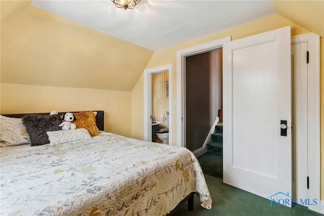 bedroom with vaulted ceiling and dark colored carpet