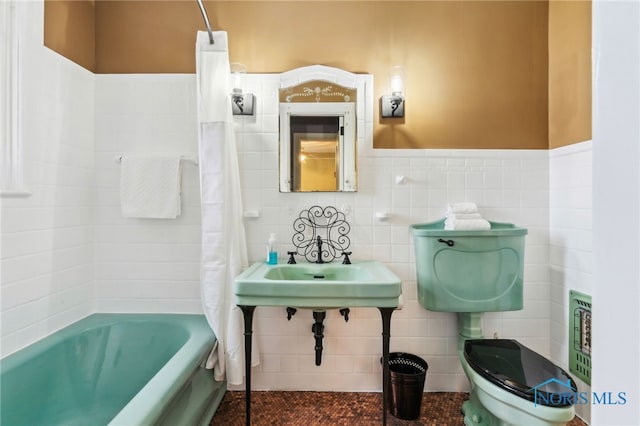 bathroom featuring toilet, tile walls, and a bath