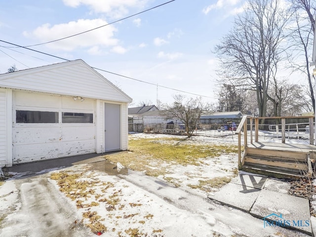 snow covered garage featuring a garage and driveway