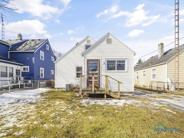 rear view of property with a yard, central AC unit, and fence