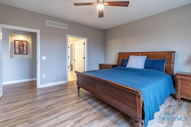 bedroom with light wood finished floors, baseboards, visible vents, and a ceiling fan