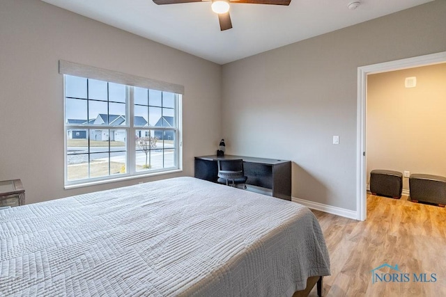 bedroom with light wood-style floors, baseboards, and a ceiling fan