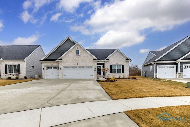 craftsman-style home featuring a garage, driveway, a front yard, and central air condition unit