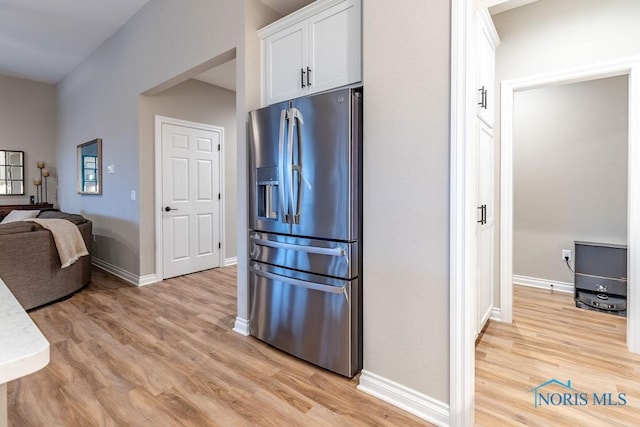 kitchen featuring light wood-style flooring, white cabinets, light countertops, and stainless steel fridge with ice dispenser