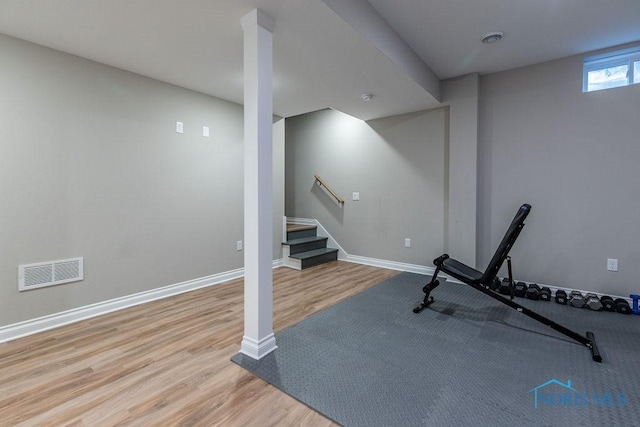 exercise room with light wood-type flooring, visible vents, and baseboards