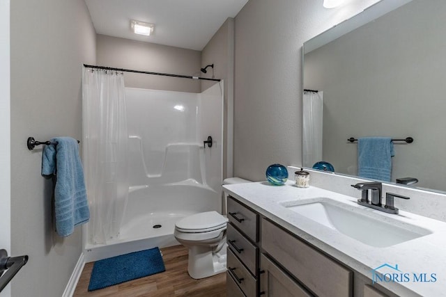 full bathroom featuring vanity, a stall shower, wood finished floors, and toilet