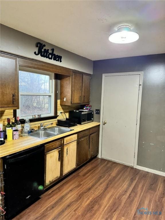 kitchen with light countertops, dishwasher, a sink, and stainless steel microwave