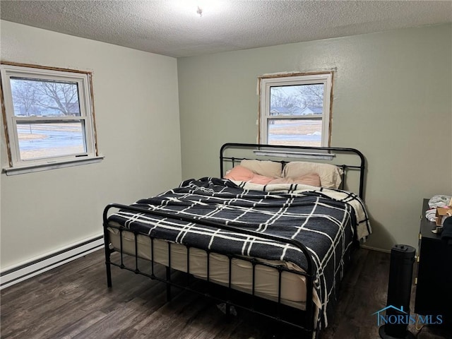 bedroom with dark wood-style floors, multiple windows, and a textured ceiling