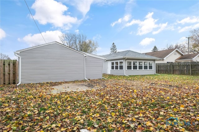 rear view of property featuring fence