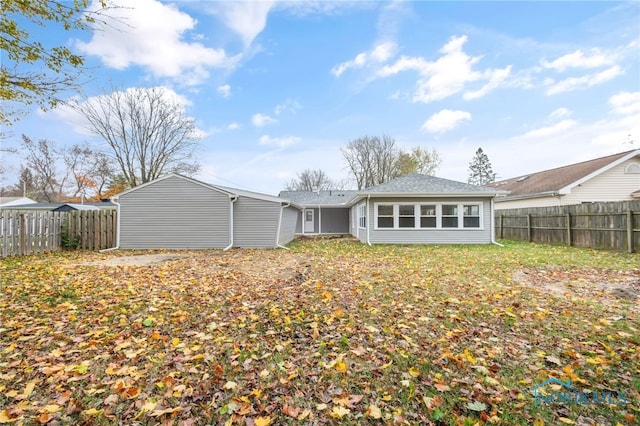 rear view of house featuring a fenced backyard