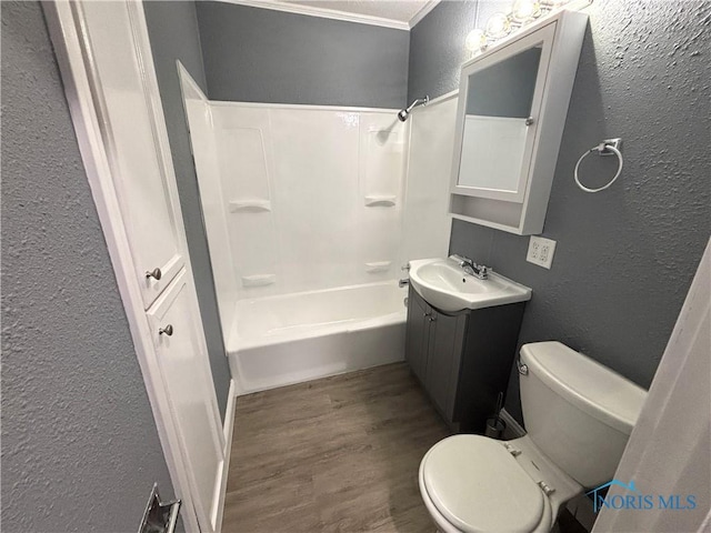 bathroom featuring a textured wall, vanity, wood finished floors, and toilet