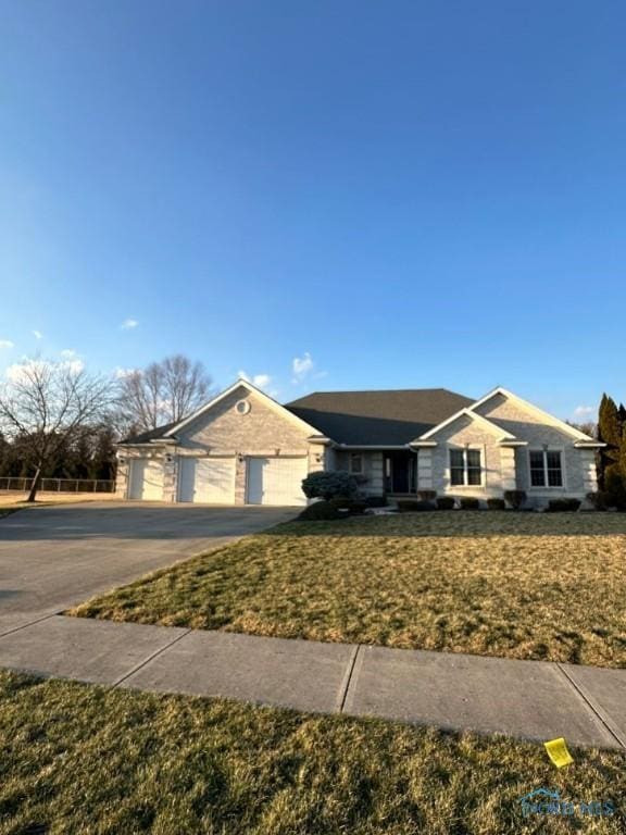 single story home featuring a detached garage and a front yard