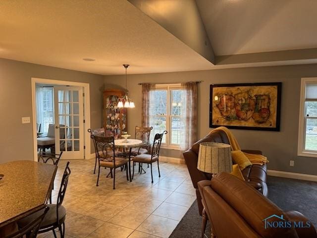 dining area with light tile patterned floors, an inviting chandelier, french doors, and baseboards