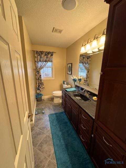 full bathroom with visible vents, baseboards, toilet, tile patterned floors, and vanity