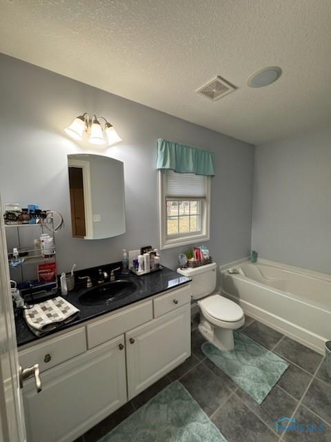 full bathroom featuring tile patterned flooring, visible vents, vanity, a bathtub, and a textured ceiling