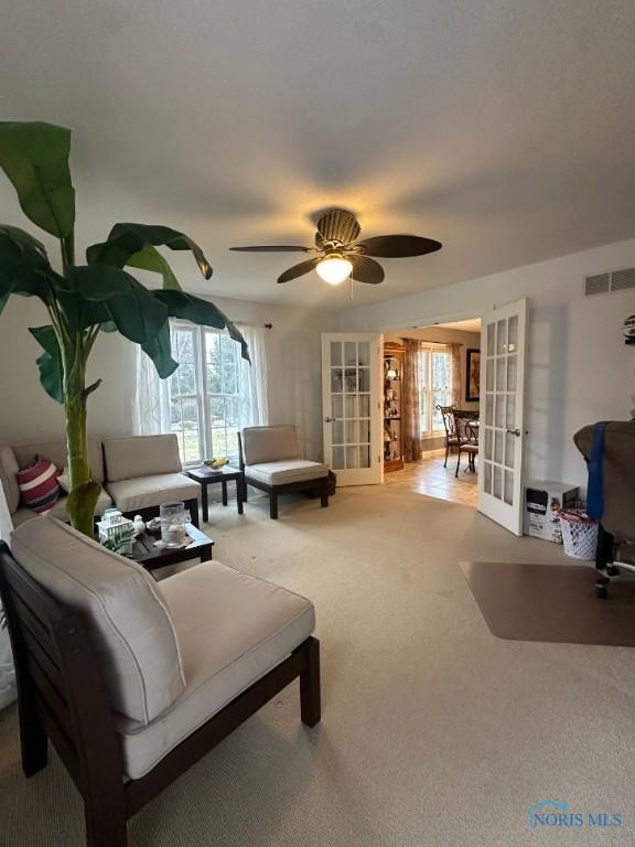 living area featuring visible vents, a healthy amount of sunlight, french doors, and carpet floors