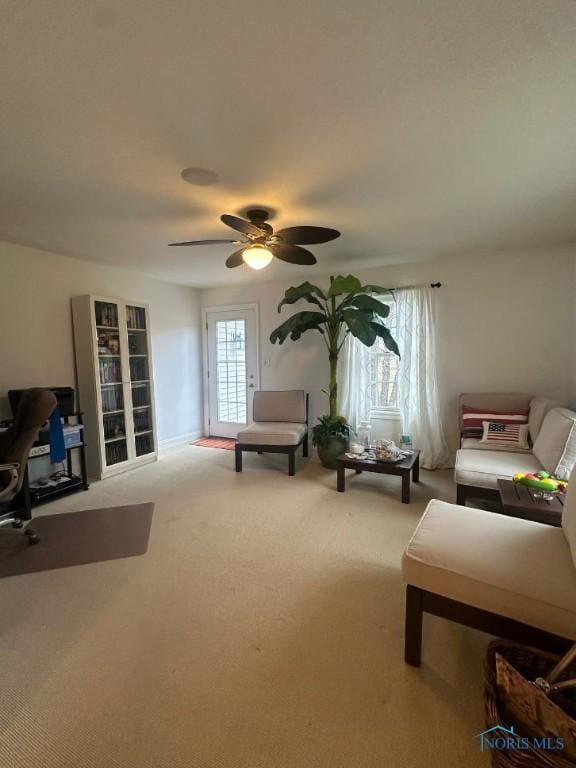 carpeted living room with ceiling fan