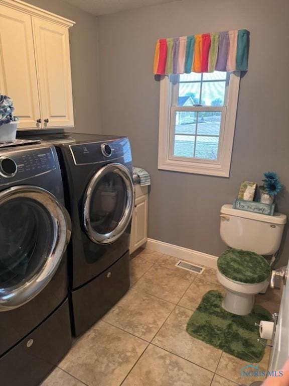 washroom with visible vents, washing machine and dryer, light tile patterned flooring, baseboards, and laundry area