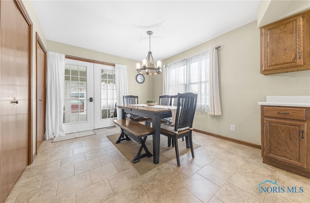 dining space with a chandelier, french doors, and baseboards