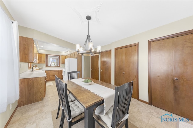 dining space with baseboards and a chandelier