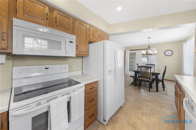 kitchen featuring a chandelier, white appliances, light countertops, brown cabinets, and pendant lighting