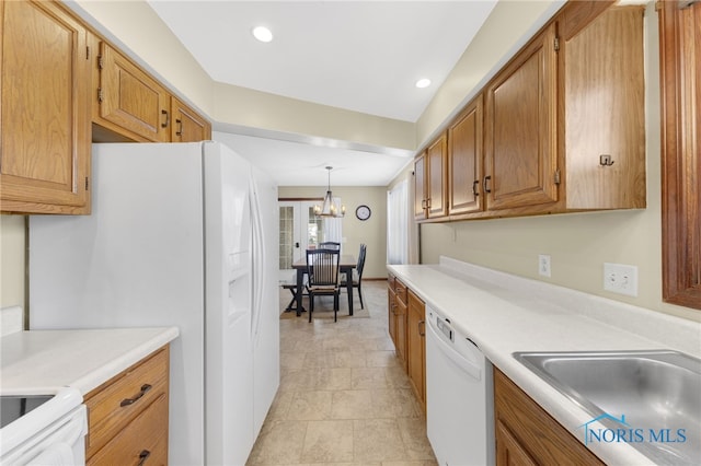 kitchen featuring brown cabinetry, white appliances, light countertops, and a sink