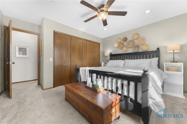 bedroom with recessed lighting, a closet, light colored carpet, and baseboards