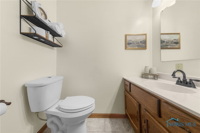 bathroom featuring tile patterned flooring, vanity, toilet, and baseboards