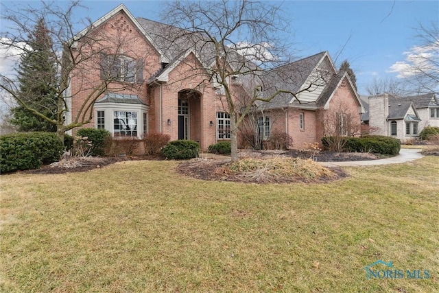 view of front of home featuring a front yard and brick siding