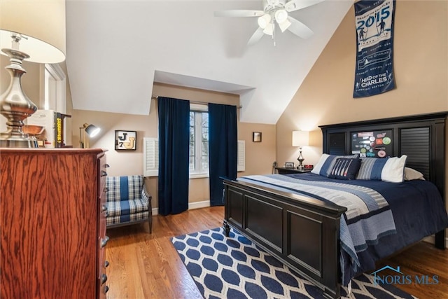 bedroom featuring vaulted ceiling, light wood finished floors, and baseboards