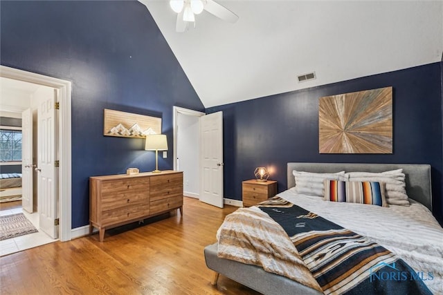 bedroom with visible vents, ceiling fan, wood finished floors, high vaulted ceiling, and baseboards