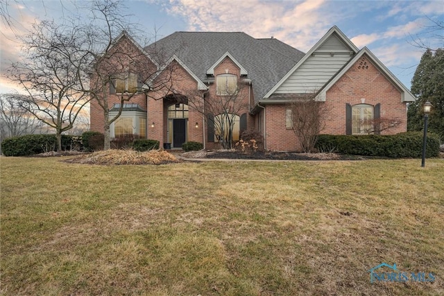 view of front of home with a front yard and brick siding