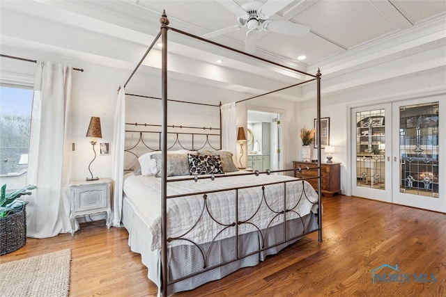 bedroom featuring french doors, crown molding, a ceiling fan, wood finished floors, and coffered ceiling