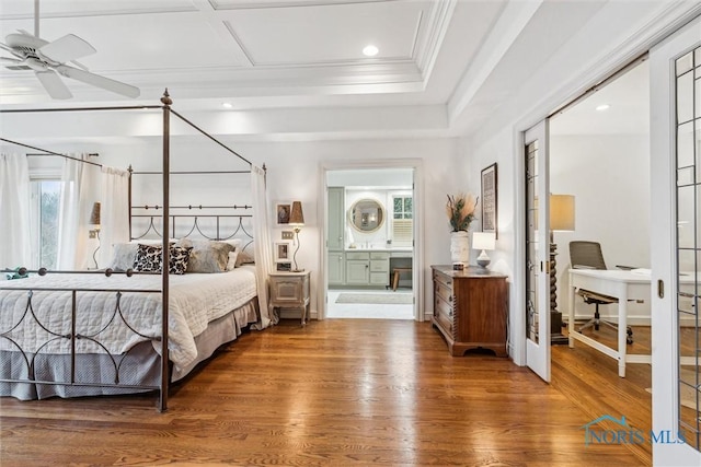 bedroom with crown molding, a closet, connected bathroom, wood finished floors, and baseboards