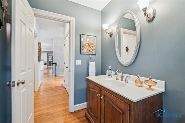 bathroom with baseboards, wood finished floors, and vanity