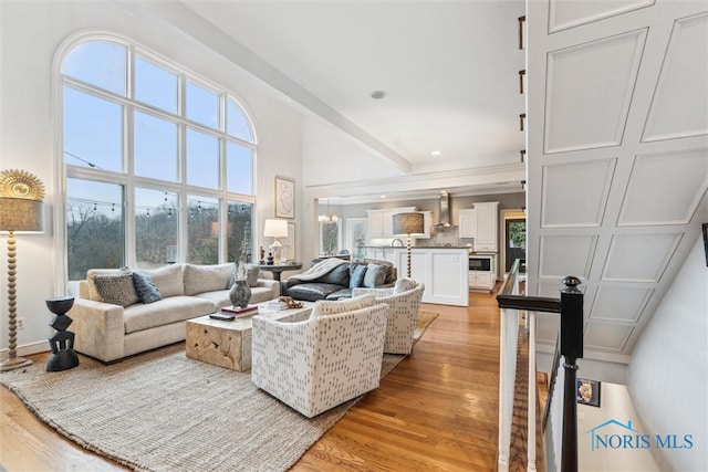 living room with a high ceiling and light wood-style flooring