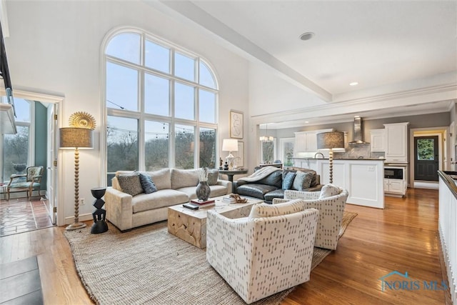 living room with light wood-style floors, a healthy amount of sunlight, and a high ceiling