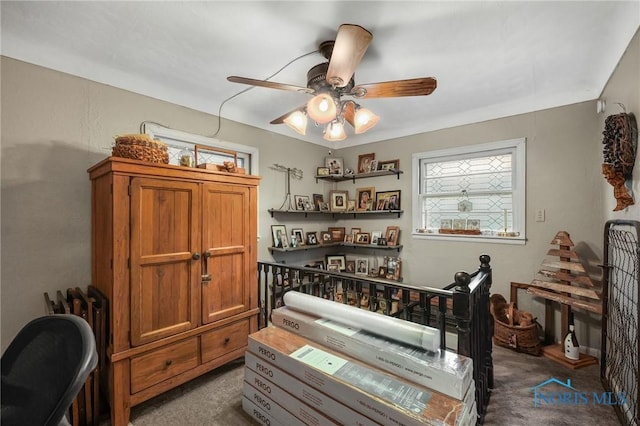 dining space featuring ceiling fan and dark carpet