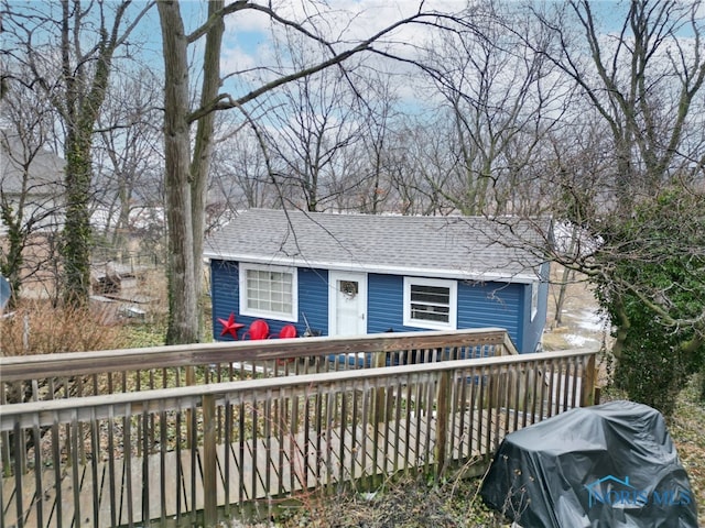 view of front of house featuring a shingled roof and a wooden deck