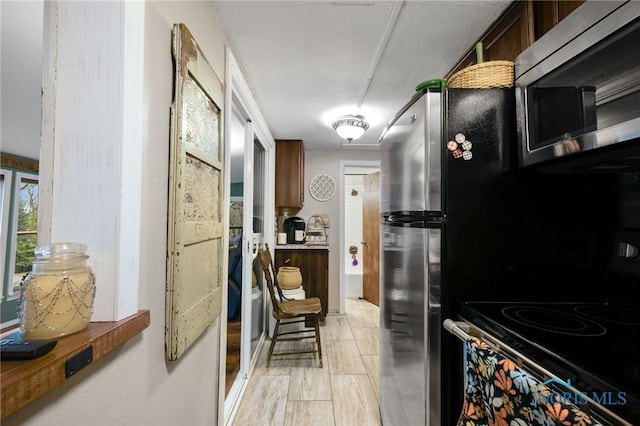 kitchen featuring stainless steel microwave, electric stove, and wood finish floors