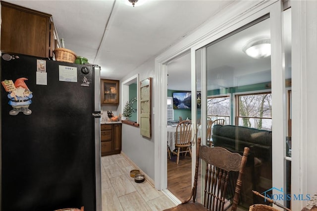 kitchen featuring glass insert cabinets and freestanding refrigerator