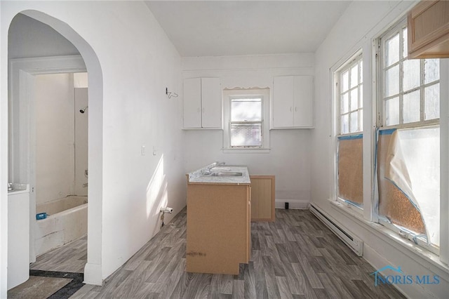 2618 Collingwood Blvd, Toledo, OH 43610 - interior space with a baseboard radiator, wood finished floors, vanity, and a tub