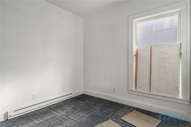 2618 Collingwood Blvd, Toledo, OH 43610 - spare room featuring baseboards, dark floors, baseboard heating, and a healthy amount of sunlight