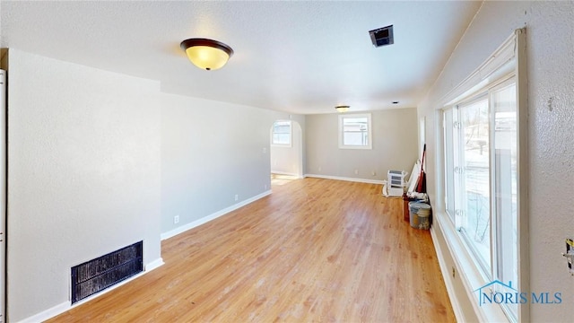 interior space with light wood-type flooring, visible vents, and baseboards