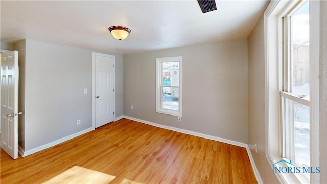 unfurnished bedroom featuring light wood finished floors, visible vents, and baseboards