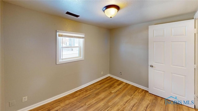 empty room featuring light wood-type flooring and baseboards