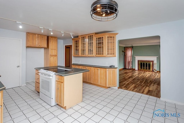 kitchen featuring a fireplace, light floors, dark countertops, electric range, and a kitchen island