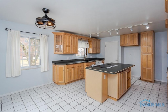 kitchen featuring black electric cooktop, a sink, baseboards, dark countertops, and glass insert cabinets